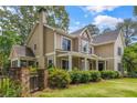 Rear exterior view of home with covered porch, stone accents, lush landscaping, and manicured lawn at 2217 Virginia Ne Pl, Atlanta, GA 30305