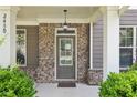 Close-up of the front porch featuring a stylish brick facade, elegant lighting, and inviting entrance door at 2450 Overlook Ave, Lithonia, GA 30058