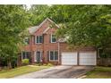 Charming two-story brick home with a two-car garage, manicured lawn, and traditional architectural details at 1130 Timbercreek Ct, Alpharetta, GA 30005