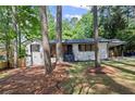 Charming renovated home with a light brick facade, modern wood accents, and mature trees at 2238 Pinecliff Ne Dr, Atlanta, GA 30345