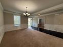Elegant living room featuring crown molding, wainscotting, large windows, and dark wood flooring accents at 3488 Woodshade Dr, Loganville, GA 30052