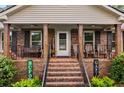 Inviting covered front porch with seating, decorative columns, and a welcoming entryway at 4010 Hamilton Mill Rd, Buford, GA 30519