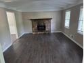Spacious living room with a stone fireplace, large windows, and modern flooring at 4015 Woodland Nw Dr, Kennesaw, GA 30152