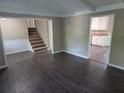 Open-concept living room with updated flooring and a view of the staircase and kitchen at 4015 Woodland Nw Dr, Kennesaw, GA 30152