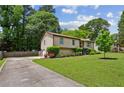 A well-maintained home featuring a long driveway, lush lawn, and thoughtfully placed shrubbery at 4192 Alaina Cir, Austell, GA 30106