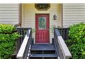 Welcoming front entryway with a decorative red door, complemented by manicured greenery and stylish fixtures at 4192 Alaina Cir, Austell, GA 30106