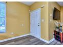 Welcoming foyer with wood-look floors, white door and television at 2326 Nicole Dr, Hampton, GA 30228