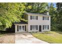 Charming two-story home with black shutters and a welcoming front yard surrounded by lush trees at 430 Pilgrim Ln, Powder Springs, GA 30127