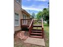 A backyard deck featuring access stairs and brick pavers that lead to the lush green yard at 5517 Rock Shoals Way, Atlanta, GA 30349