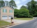 Two-story home featuring a two-car garage, well-kept lawn, and traditional architectural design at 5517 Rock Shoals Way, Atlanta, GA 30349