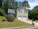 Charming two-story home with a well-manicured lawn, attached garage, and inviting green door at 5517 Rock Shoals Way, Atlanta, GA 30349