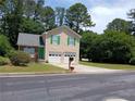 Charming two-story home with a well-manicured lawn, attached garage, and inviting green door at 5517 Rock Shoals Way, Atlanta, GA 30349