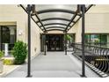 Building entrance features an awning, black metal railings and lush landscaping at 1421 Peachtree Ne St # 203, Atlanta, GA 30309