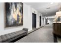 Hallway view featuring elevator access, modern artwork, and a seating area for residents at 1421 Peachtree Ne St # 203, Atlanta, GA 30309