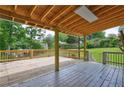 Large, covered deck with wooden floors, railings, and support beams perfect for entertaining outdoors at 1492 Harbins Rd, Norcross, GA 30093