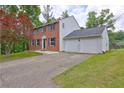 Side view of a brick home with a concrete driveway leading to a spacious two car garage at 1492 Harbins Rd, Norcross, GA 30093