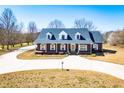 Beautiful brick home boasts a covered front porch, dormer windows, and a long, curved driveway at 111 Dixson Rd, Bowdon, GA 30108