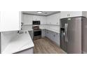 Well-appointed kitchen featuring stainless steel appliances, white upper cabinets, and gray lower cabinets at 2317 Baywood Se Dr, Atlanta, GA 30315