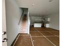 Open-concept floor plan showing a staircase, living area and eat-in kitchen with white cabinets at 5108 Arista Dr, Douglasville, GA 30135
