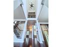 Elegant foyer boasting a staircase with iron spindles, hardwood floors, and an open view to living spaces at 4056 Kingsley Park Ct, Peachtree Corners, GA 30096
