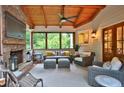 Relaxing back porch with a stone fireplace, comfortable seating, and natural wood ceiling at 3510 Woodbury Creek Dr, Cumming, GA 30041