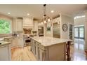 Bright kitchen with custom cabinets, a large center island, stainless appliances, and hardwood floors at 3510 Woodbury Creek Dr, Cumming, GA 30041