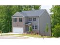 Charming two-story home with gray siding and brick accents, complemented by a well-manicured lawn and landscape at 1591 Oakbrook Pond Place, Dacula, GA 30019