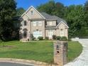 Beautiful brick home featuring a well-kept lawn and driveway, complemented by professional landscaping at 3152 Meadow Glade Ct, Lithonia, GA 30038