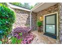 Inviting front entrance with beautiful stone detail, lush landscaping and cozy outdoor lighting at 41 Basswood Cir, Sandy Springs, GA 30328