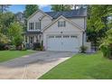 Inviting two-story home featuring a manicured lawn and attached two-car garage at 779 Sanders Rd, Cumming, GA 30041