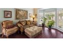 Cozy living room with bay windows, tapestry, comfortable seating, and beautiful hardwood floors at 1274 Ridge Vista Ct, Lawrenceville, GA 30043