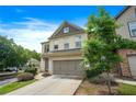 Attractive two-story townhome with a two-car garage, well-kept lawn, and mature trees at 5830 Keystone Pt, Lithonia, GA 30058
