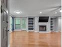 Bright living room features a fireplace, built-in shelves, wood floors, and sliding glass doors at 1015 Dunbar Dr, Dunwoody, GA 30338