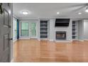 Open-concept living room featuring hardwood floors, fireplace and built in bookshelves at 1015 Dunbar Dr, Dunwoody, GA 30338