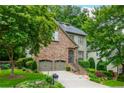 Charming stone front home featuring a well manicured yard with mature trees and an attached two car garage at 3182 Windsor Lake Ne Dr, Atlanta, GA 30319