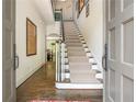 Spacious foyer with hardwood floors, staircase with patterned carpet and crisp, neutral paint at 3182 Windsor Lake Ne Dr, Atlanta, GA 30319