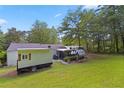 Expansive backyard with lush lawn, mature trees, and various outdoor recreational amenities at 3184 Newcastle Way, Snellville, GA 30039