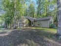 Home exterior features a wooded lot, neutral colors, and multiple windows allowing for ample natural light at 5334 Post Road Pass, Stone Mountain, GA 30088