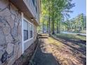 View of the stone and siding exterior of a home, showcasing the walkway and surrounding landscape at 5334 Post Road Pass, Stone Mountain, GA 30088