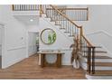Bright foyer with hardwood floors, grand staircase with modern black railings, and stylish decor at 605 Buttercup Trce, Johns Creek, GA 30022