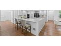 Spacious kitchen with white cabinets, marble countertops, large island, and stainless steel appliances at 605 Buttercup Trce, Johns Creek, GA 30022