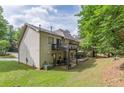 View of the backyard with a deck, patio area, and green lawn. Outdoor entertaining spaces. Mature trees at 709 Eastwood Rise, Stone Mountain, GA 30087