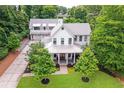 Beautiful aerial view of a pristine white farmhouse with a detached three car garage at 201 Dobbs Rd, Woodstock, GA 30188