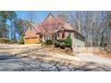 Lovely brick two-story home showcasing mature landscaping, a 2-car garage, and a welcoming driveway on a sunny day at 5034 Kingsbridge Pass, Powder Springs, GA 30127