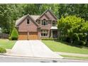 Beautiful two-story brick home features a well-kept lawn, mature trees, and a convenient two-car garage at 5034 Kingsbridge Pass, Powder Springs, GA 30127