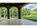 Covered patio with brick columns, providing a shaded outdoor space with views of the expansive backyard at 8340 Royal Melbourne Way, Duluth, GA 30097