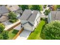 View of back of home with two-car garage, green lawn, and wooden fence at 3826 Baxley Village Trl, Suwanee, GA 30024