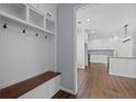 Mud room featuring custom built-ins with bench, hooks, and storage, seamlessly flowing into a stylish updated kitchen at 3826 Baxley Village Trl, Suwanee, GA 30024