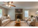 Staged living room featuring a stone fireplace, comfortable seating, and stylish decor at 6015 Sumit Nw Ct, Kennesaw, GA 30152