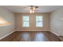 Living room with wood flooring and ceiling fan, providing ample space and natural light at 6015 Sumit Nw Ct, Kennesaw, GA 30152